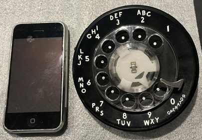 First generation iPhone A1203 next to a 500-series rotary dial